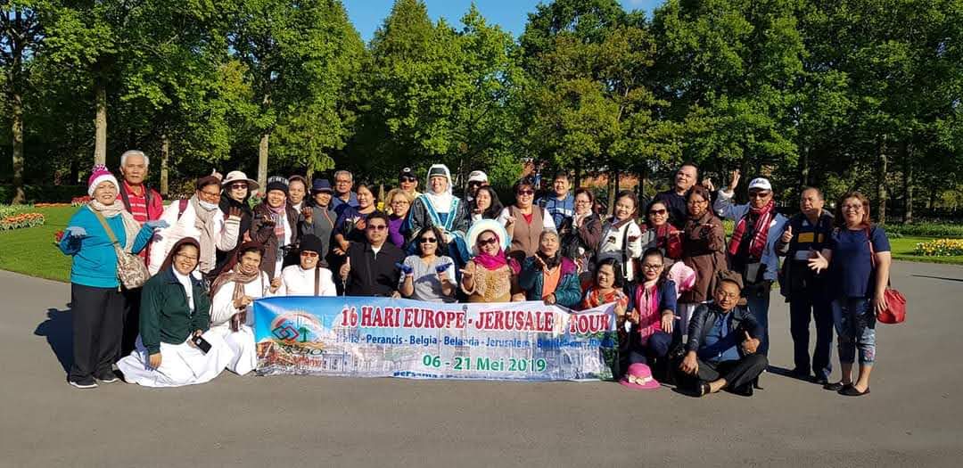 Rombongan Okdo Tours berfoto di taman dengan spanduk 16 Hari Europe Jerusalem Tour