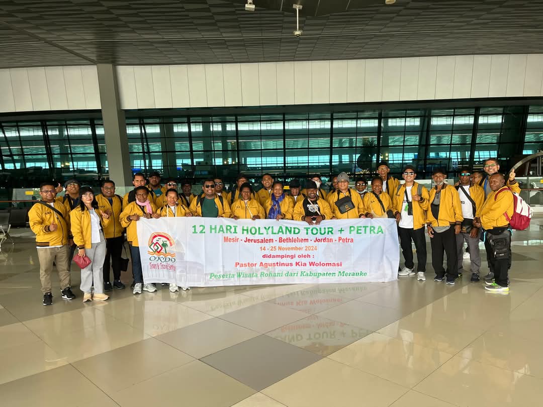Peserta Okdo Tours berfoto dengan spanduk Holyland dan Petra